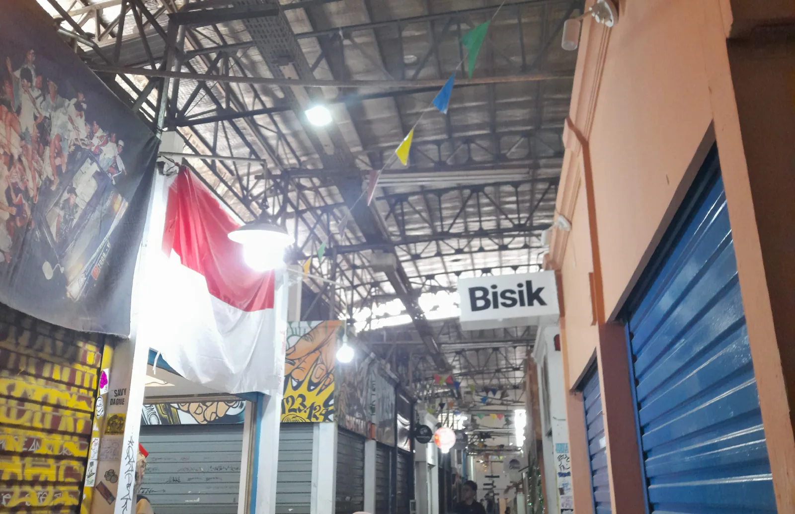 Indoor market corridor at Pasar Santa, Jakarta, with Indonesian flag and creative vendor stalls