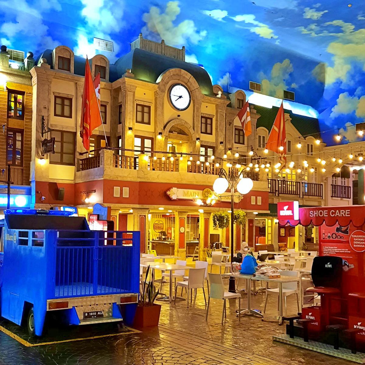 The indoor mini-city main square at KidZania Jakarta, with scaled-down buildings and a child-sized delivery truck