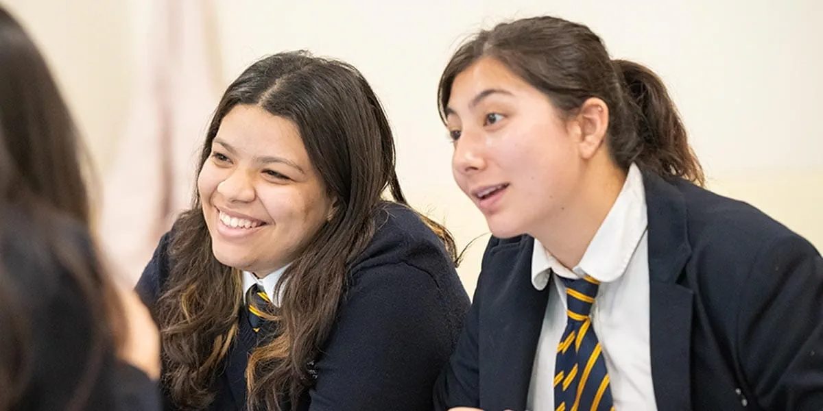 Two pupils in ISJ uniform talking during a lesson