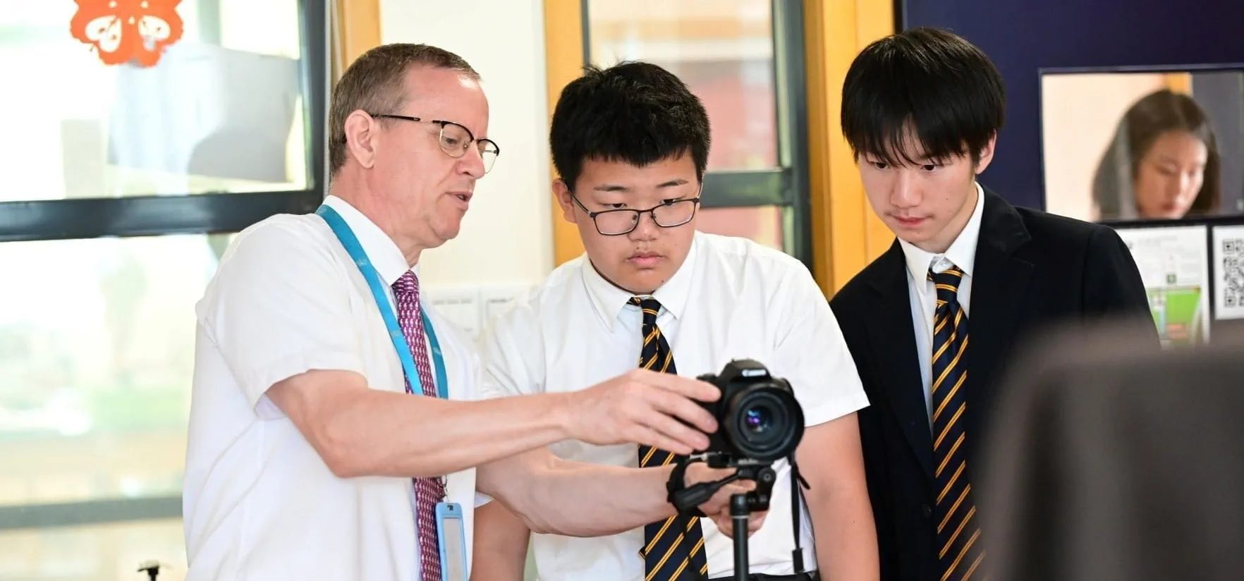 A teacher working alongside two pupils during a lesson at ISJ Jakarta
